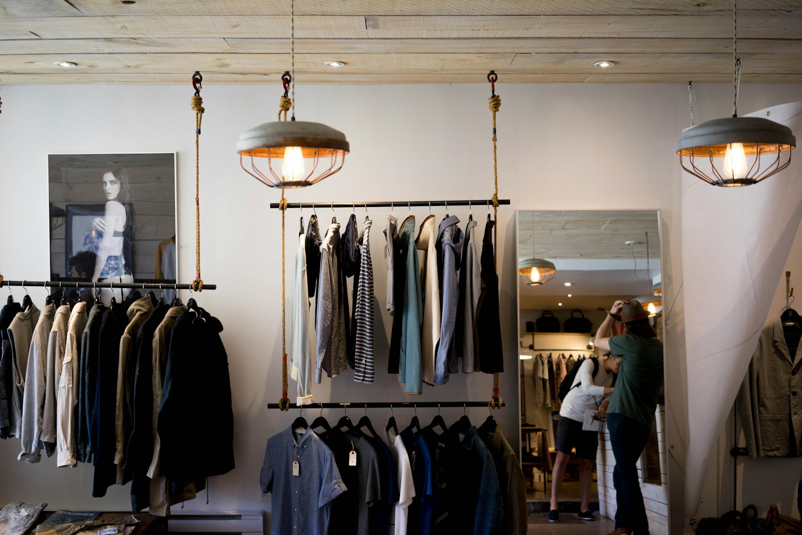 Garments hanging on rails inside a small warm-lit shop