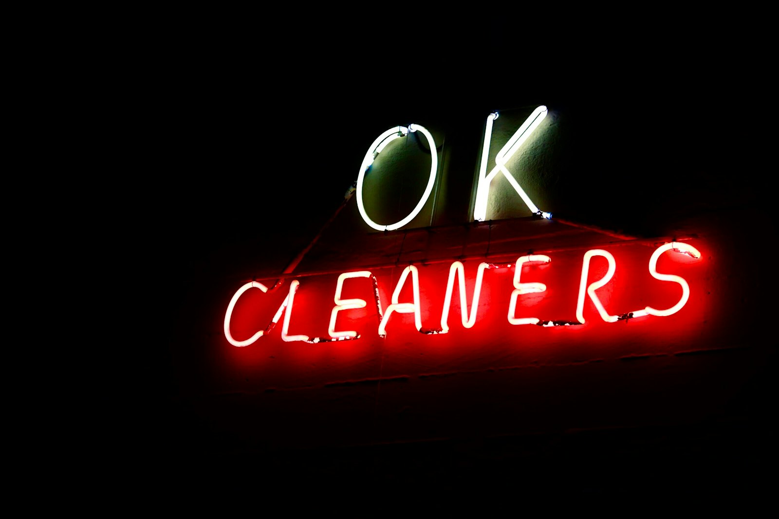 Retro neon cleaners sign glowing over a storefront