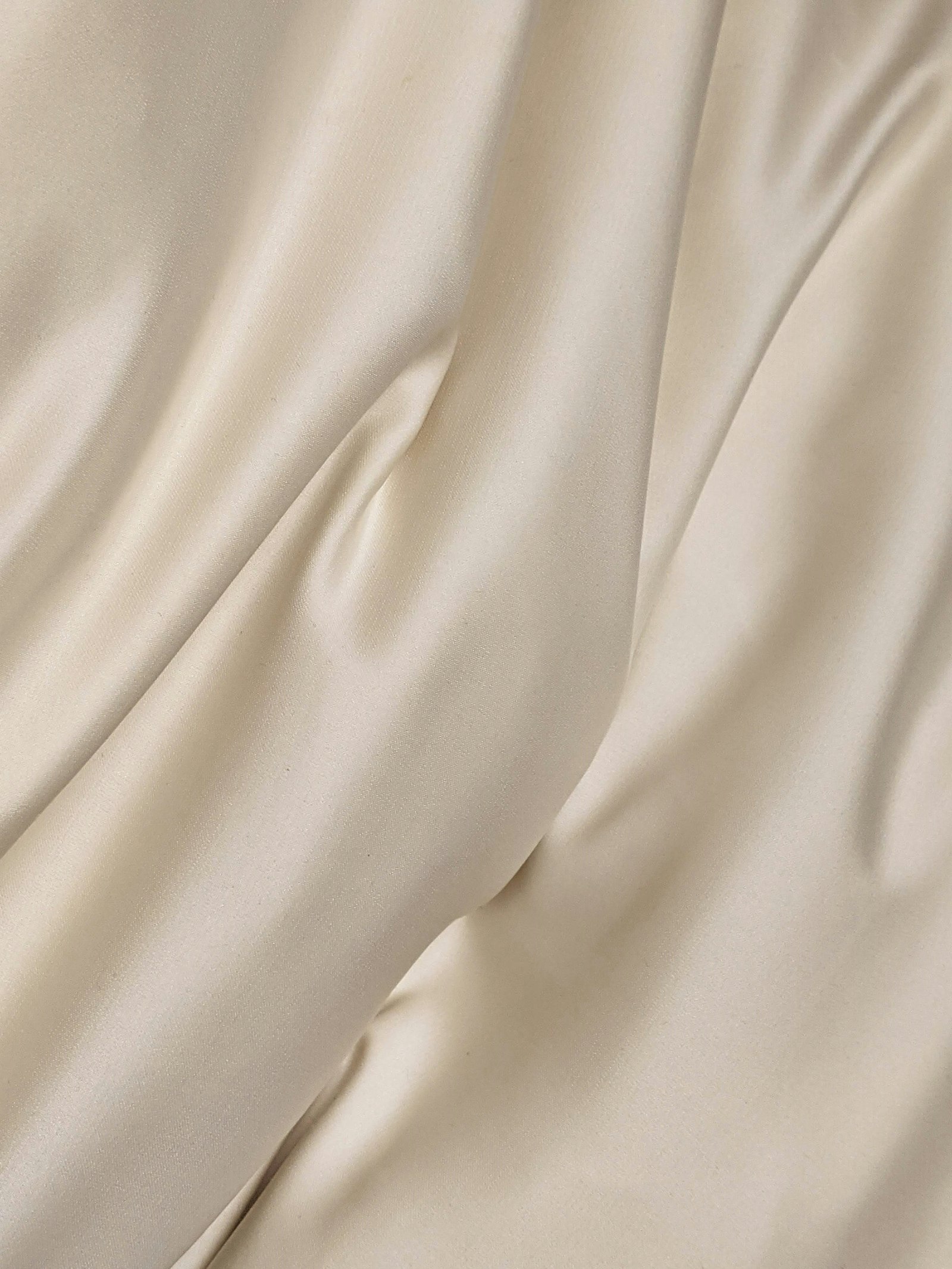 Cream satin folded into deep shadow after finishing