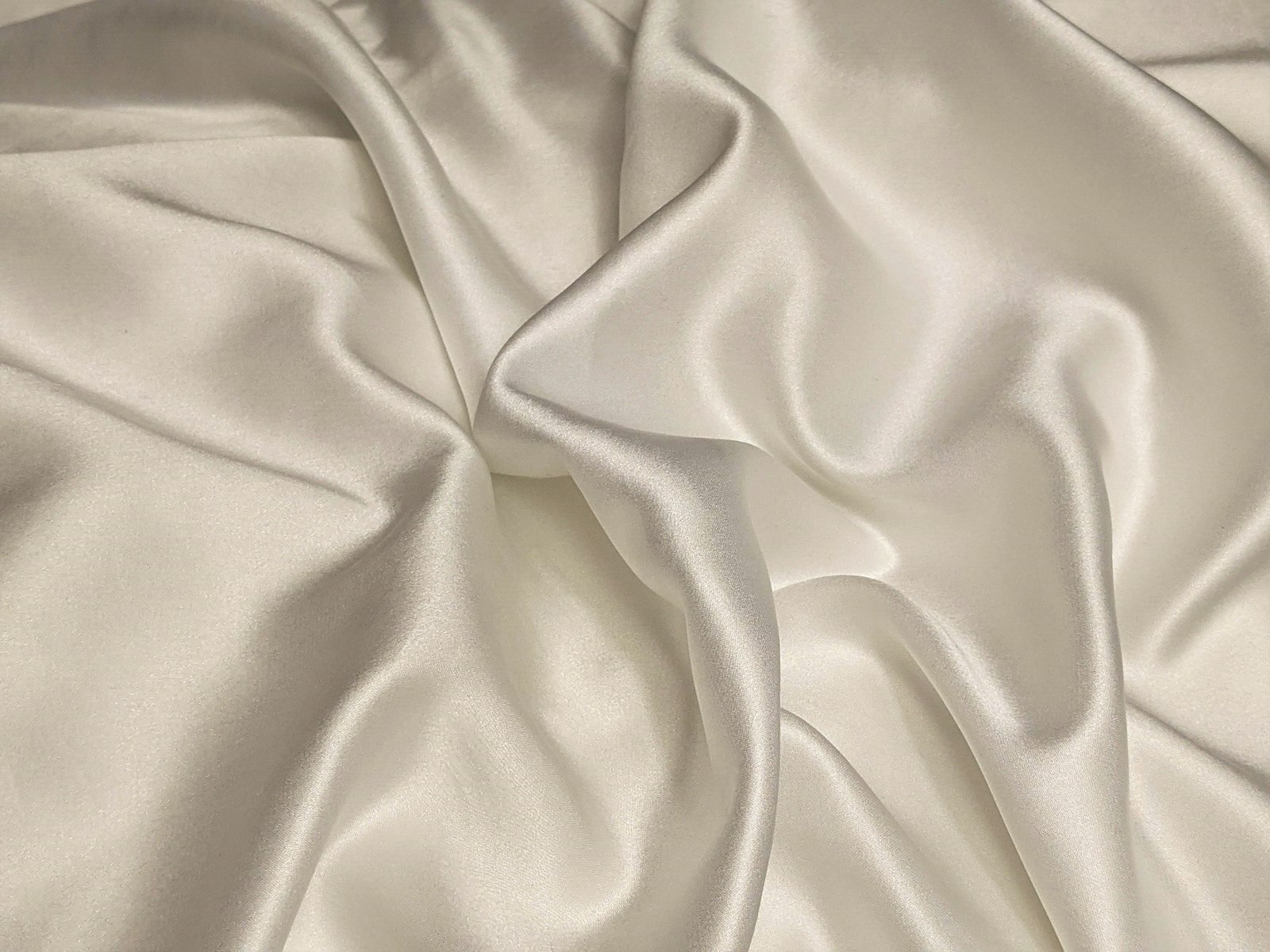Soft folds of white silk, the fabric a spotting bone spares