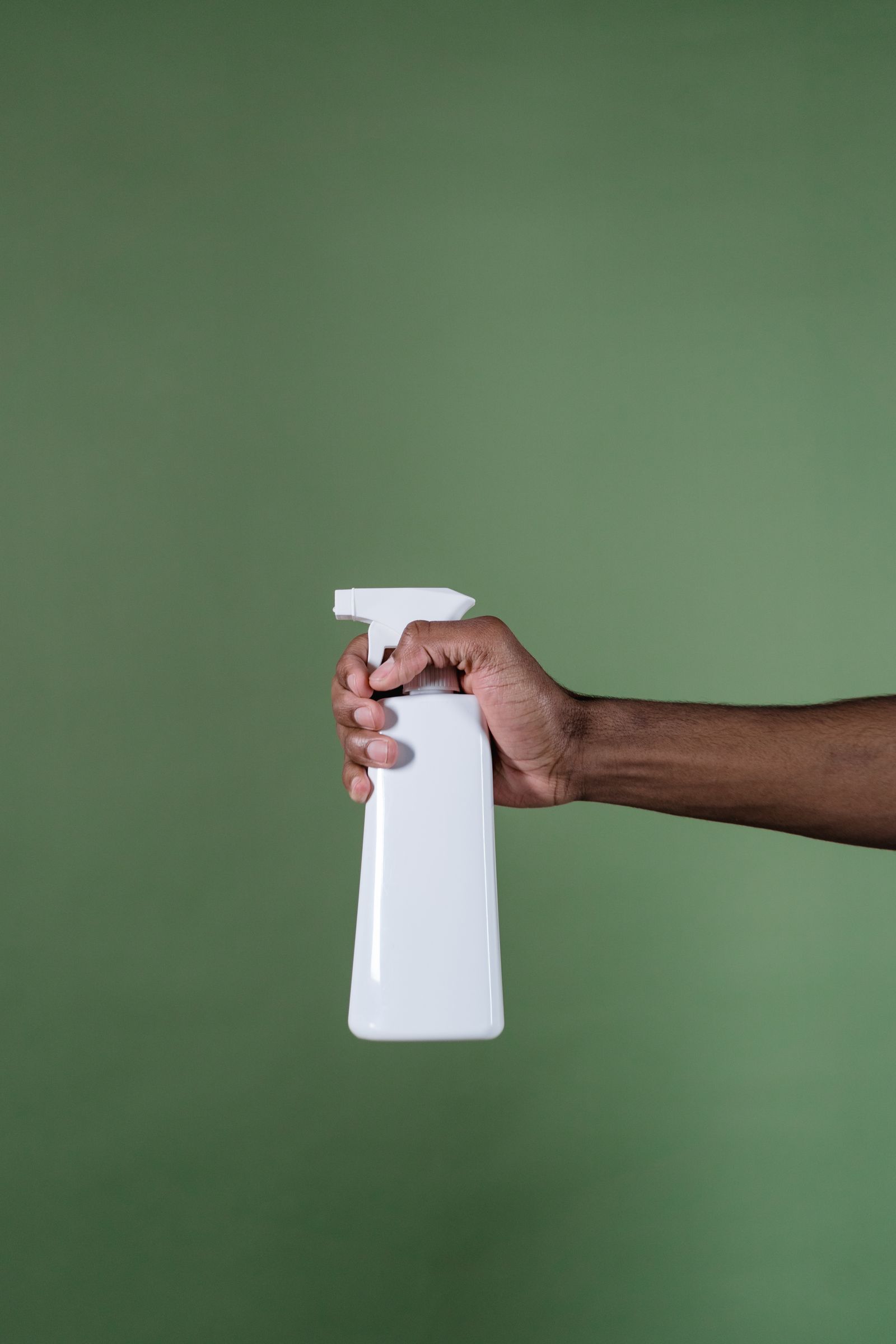 Hand holding a spray bottle of stain treatment solution