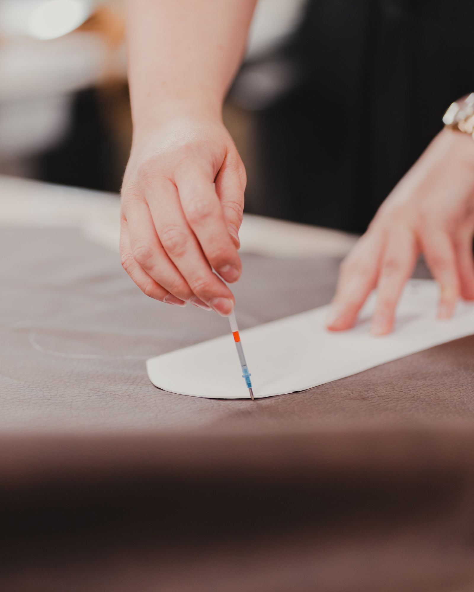 A tailor's hands measuring a length of fabric