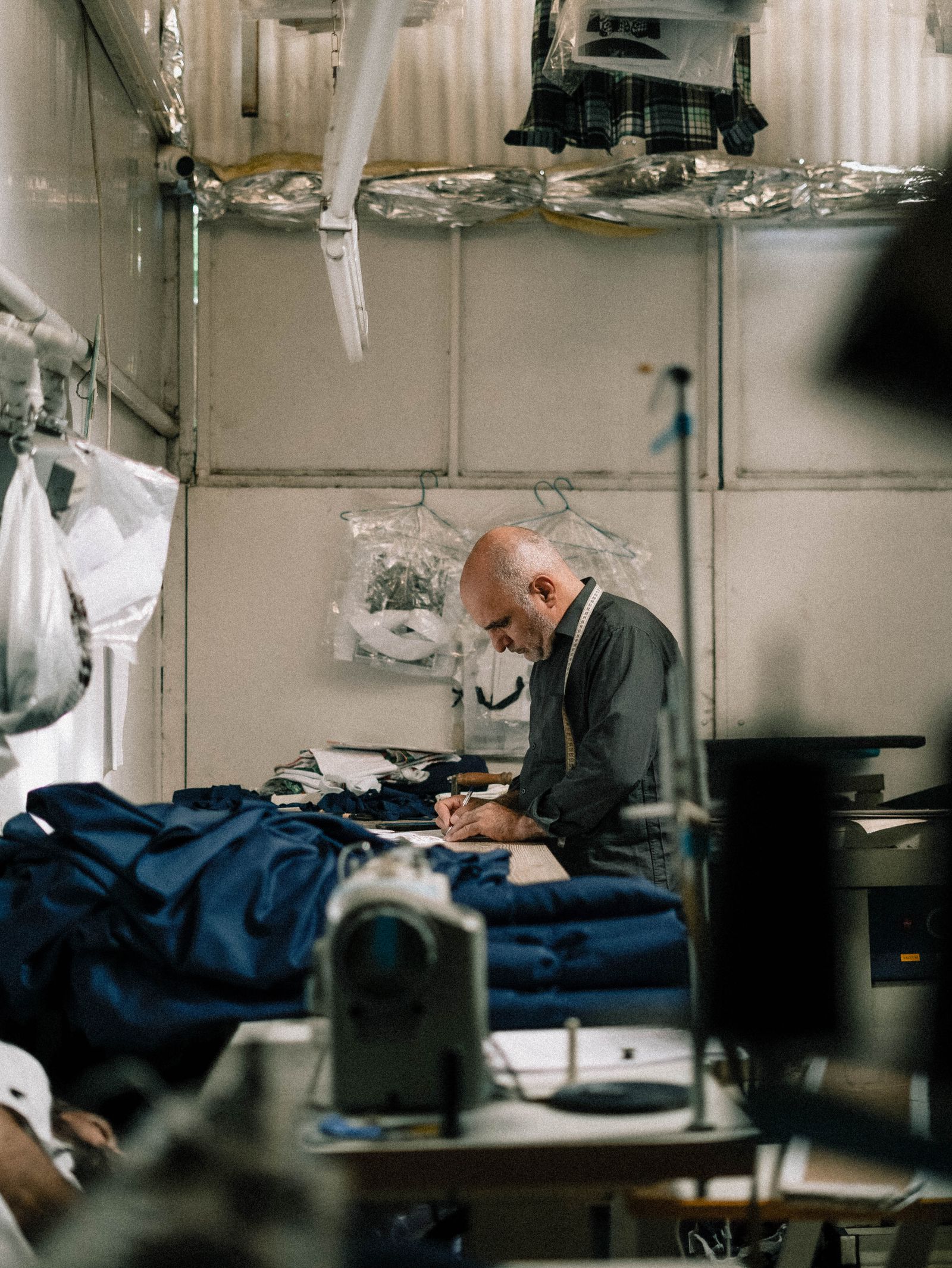 Hands checking a garment at a warm workshop bench