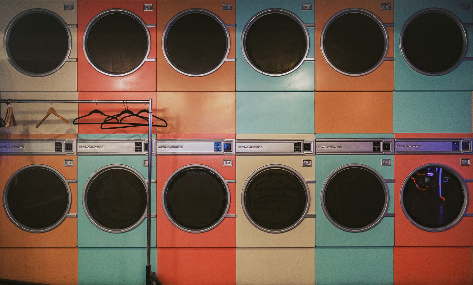 Rows of colourful washing machines inside a vintage laundromat